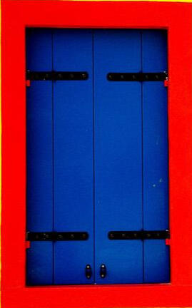 A photo of a closed window with wooden, blue shutters and a red window frame. Below it is an arrow pointing to the window.